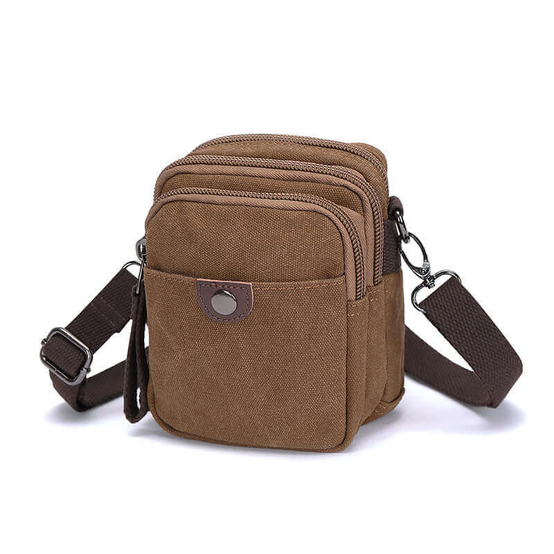 Coffee canvas small crossbody bag highlighting the zippers.