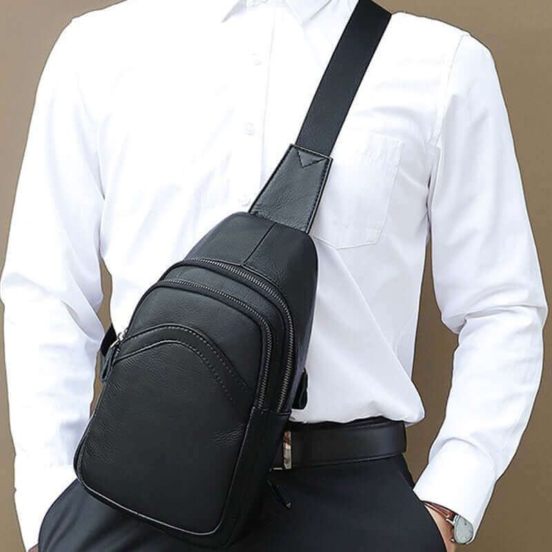 Adjustable strap on a men's black leather crossbody sling bag for comfort.