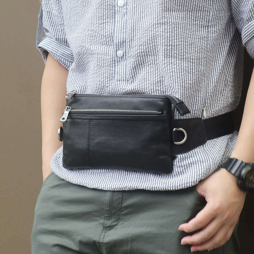 Crossbody black leather bag with multiple zippered compartments.