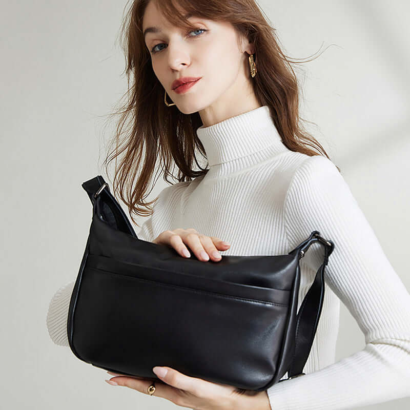 Black crossbody bag size in hand for scale