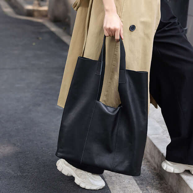 Women's black leather tote bag carried on shoulder