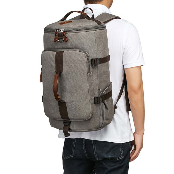 Model carrying canvas backpack in traditional backpack style