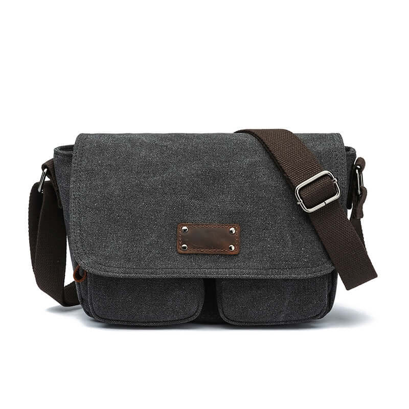 Black canvas satchel bag with vintage design and multiple pockets.
