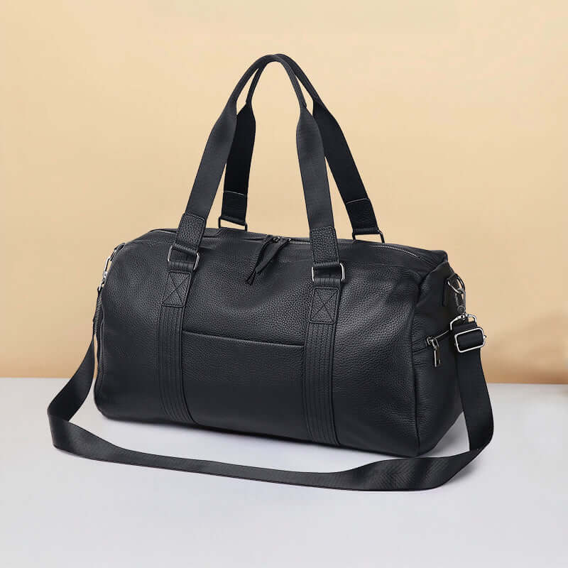 Elegant black leather duffle bag on a neutral background