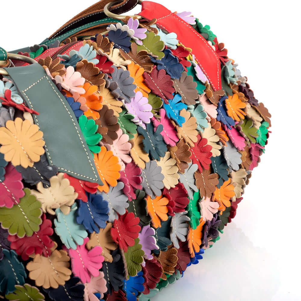 Close-up of colorful floral patchwork on leather tote bag.