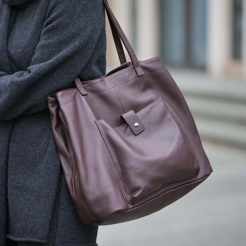 Model carrying vintage leather tote bag on shoulder – street style