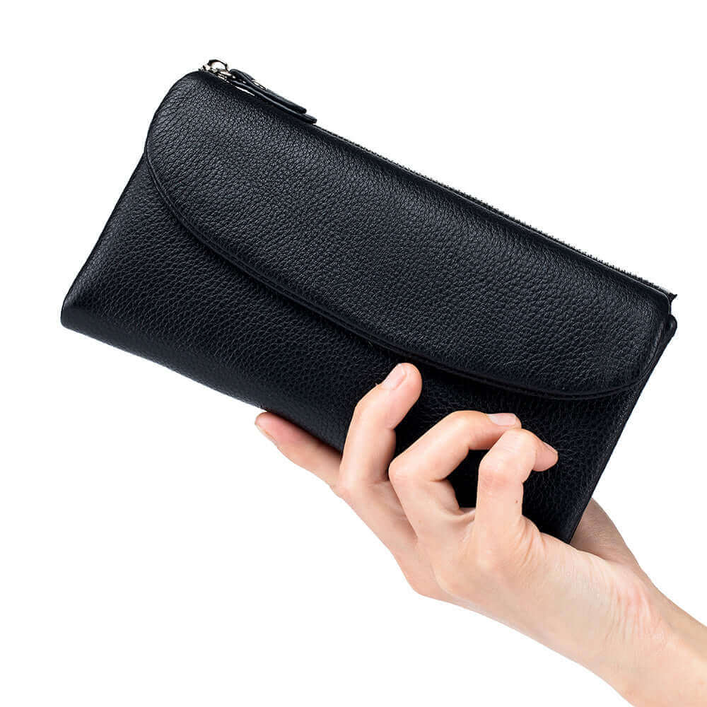 Black leather long wallet being held in hand, showcasing its compact size.