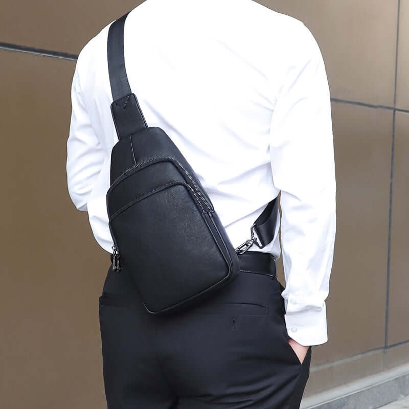 Model wearing a black leather sling bag crossbody style.