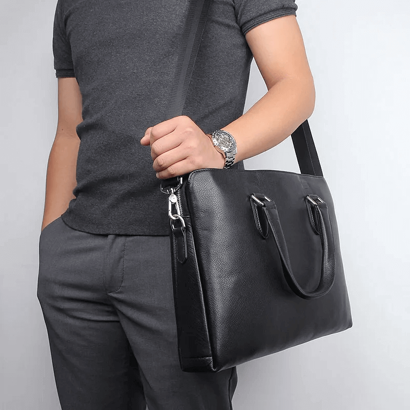 Man carrying a versatile leather briefcase suitable for a 14-inch laptop.