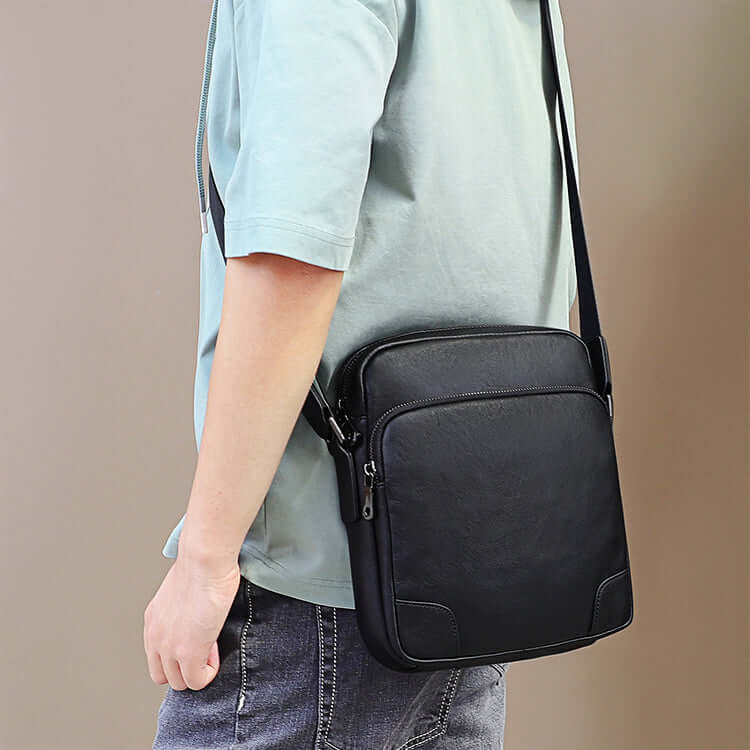 Adjustable shoulder strap of the men's black leather crossbody bag for comfort and convenience.