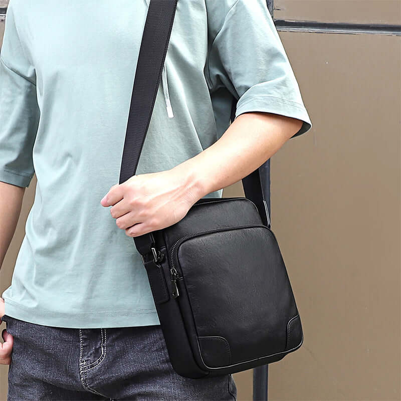 Men's leather crossbody bag in use, styled for daily commutes and travel.