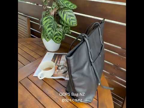 Women's black leather tote bag with spacious compartments for daily use.