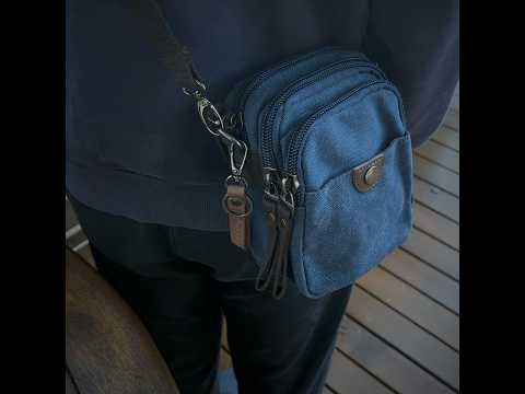 Blue canvas small crossbody bag with waist clip and carabiner.