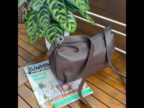 Coffee leather crossbody bag worn by a model for casual styling.