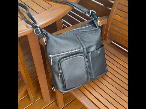 Stylish black leather backpack worn as a shoulder bag.