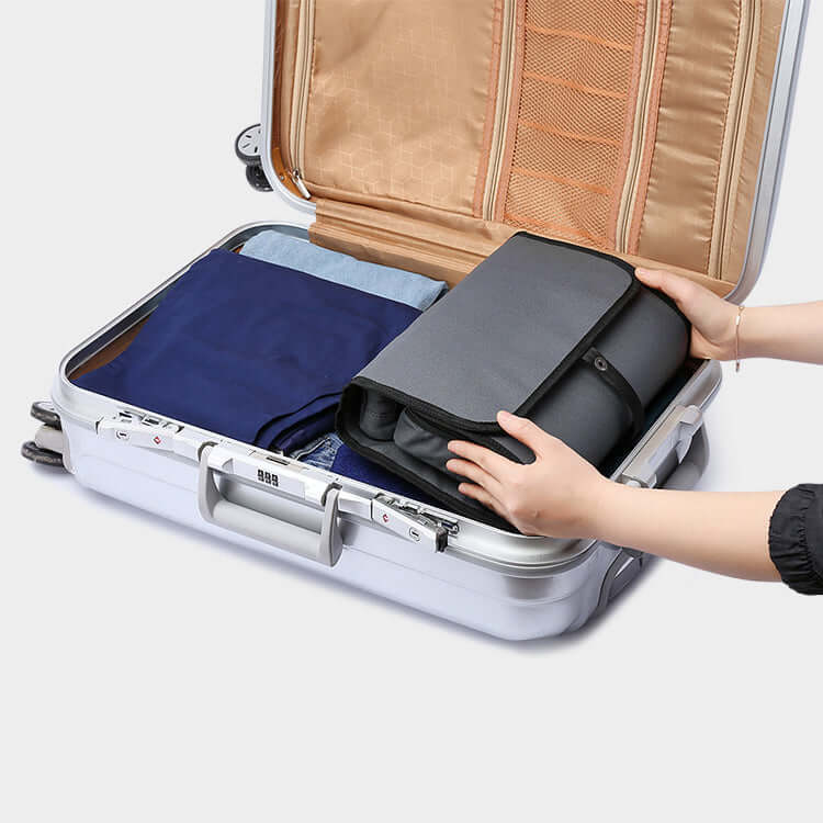 Travel toiletry bag shown packed inside a suitcase