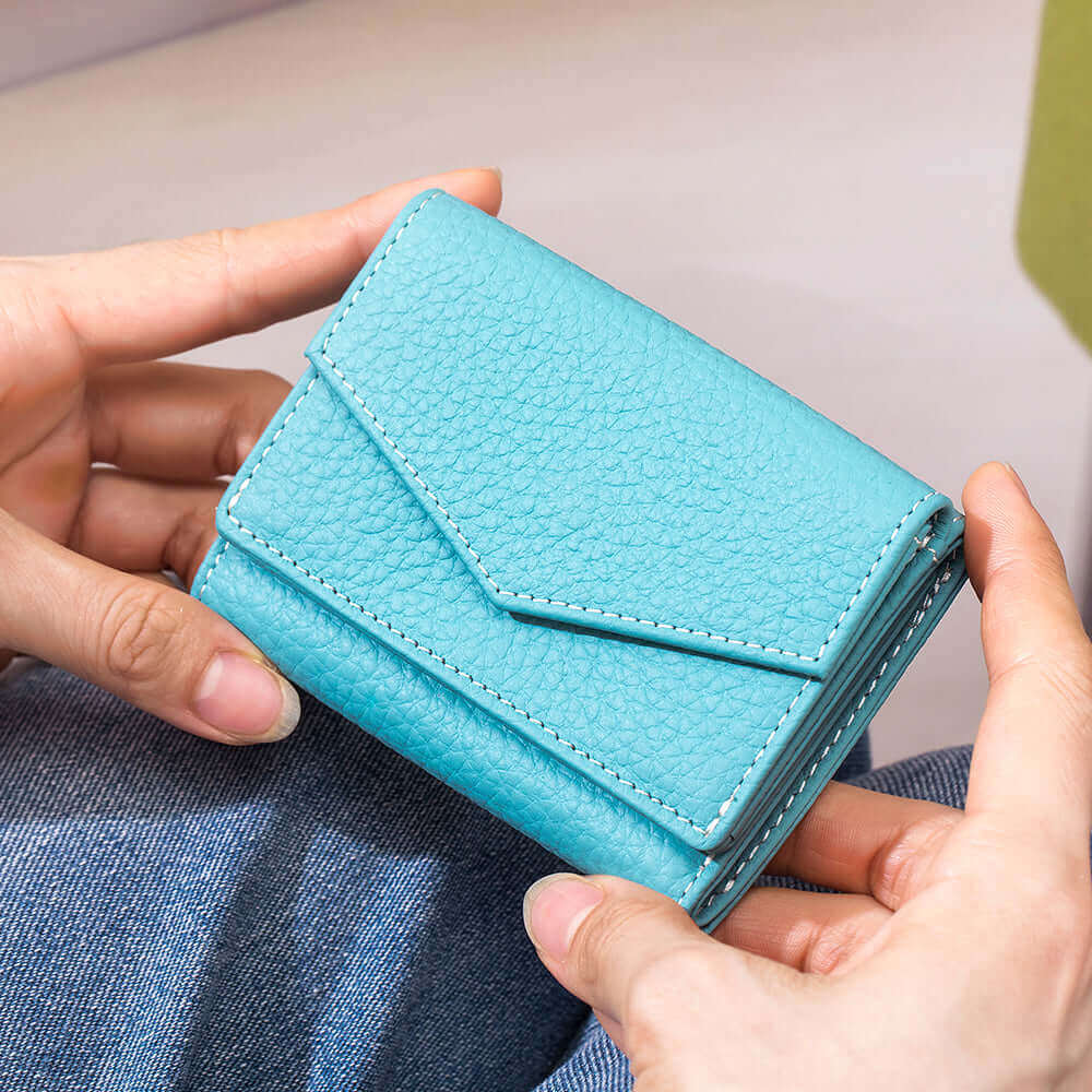 Compact size leather tri-fold wallet held in hand

