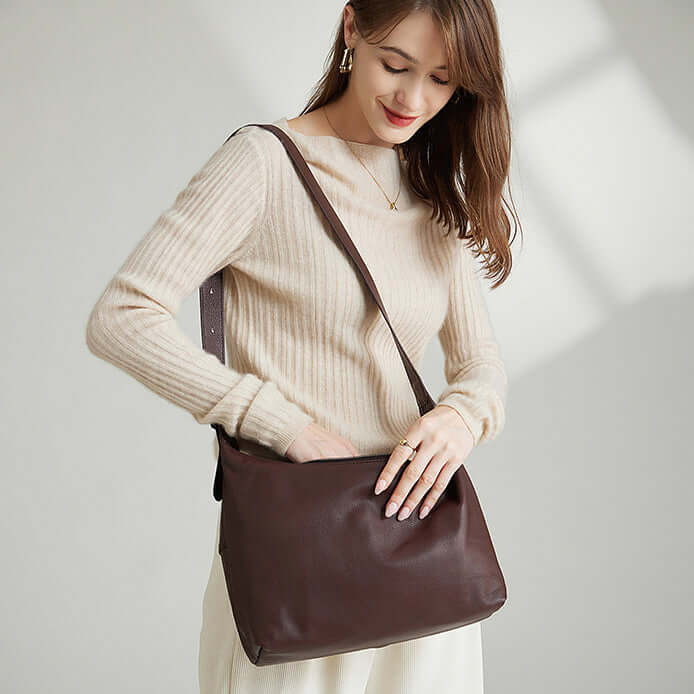 Model carrying a women's coffee brown leather shoulder and crossbody bag.