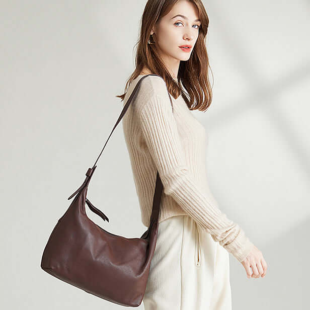 Model carrying a women's leather shoulder and crossbody bag.