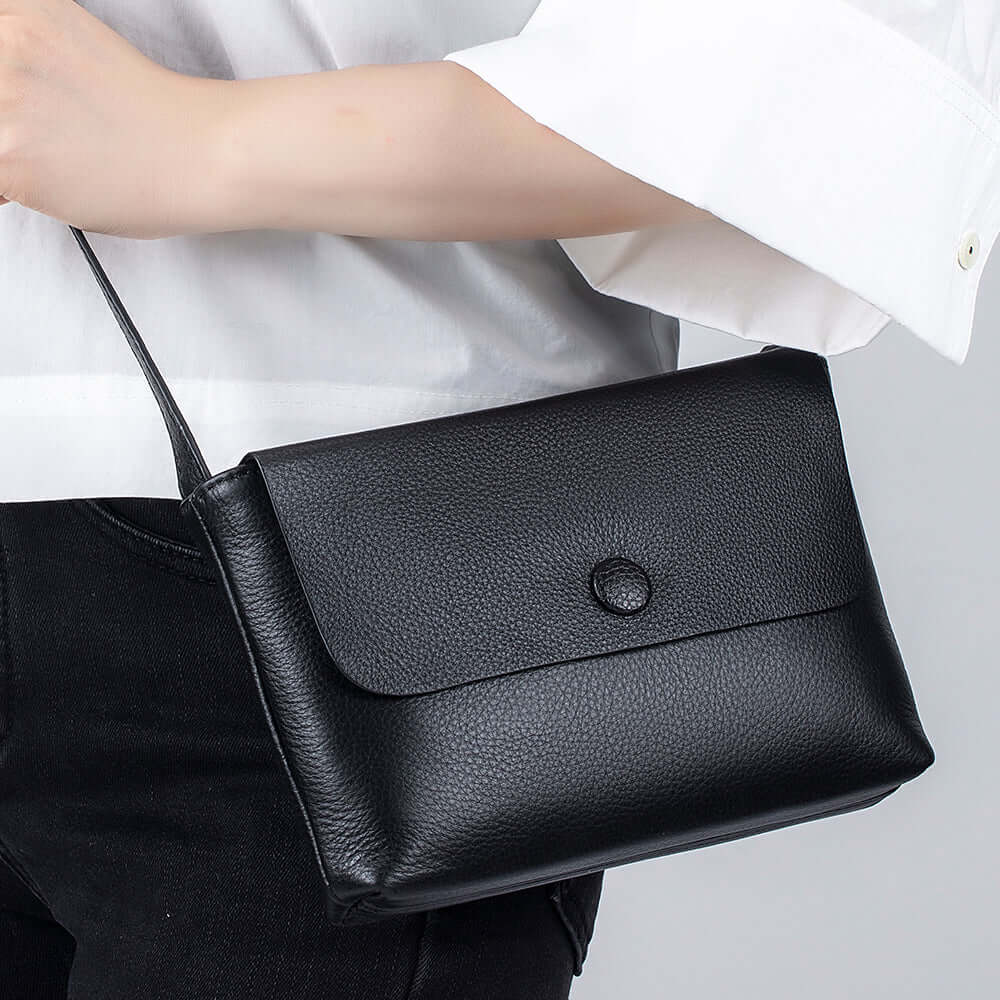 Closeup of the high-quality black leather on a small crossbody bag.