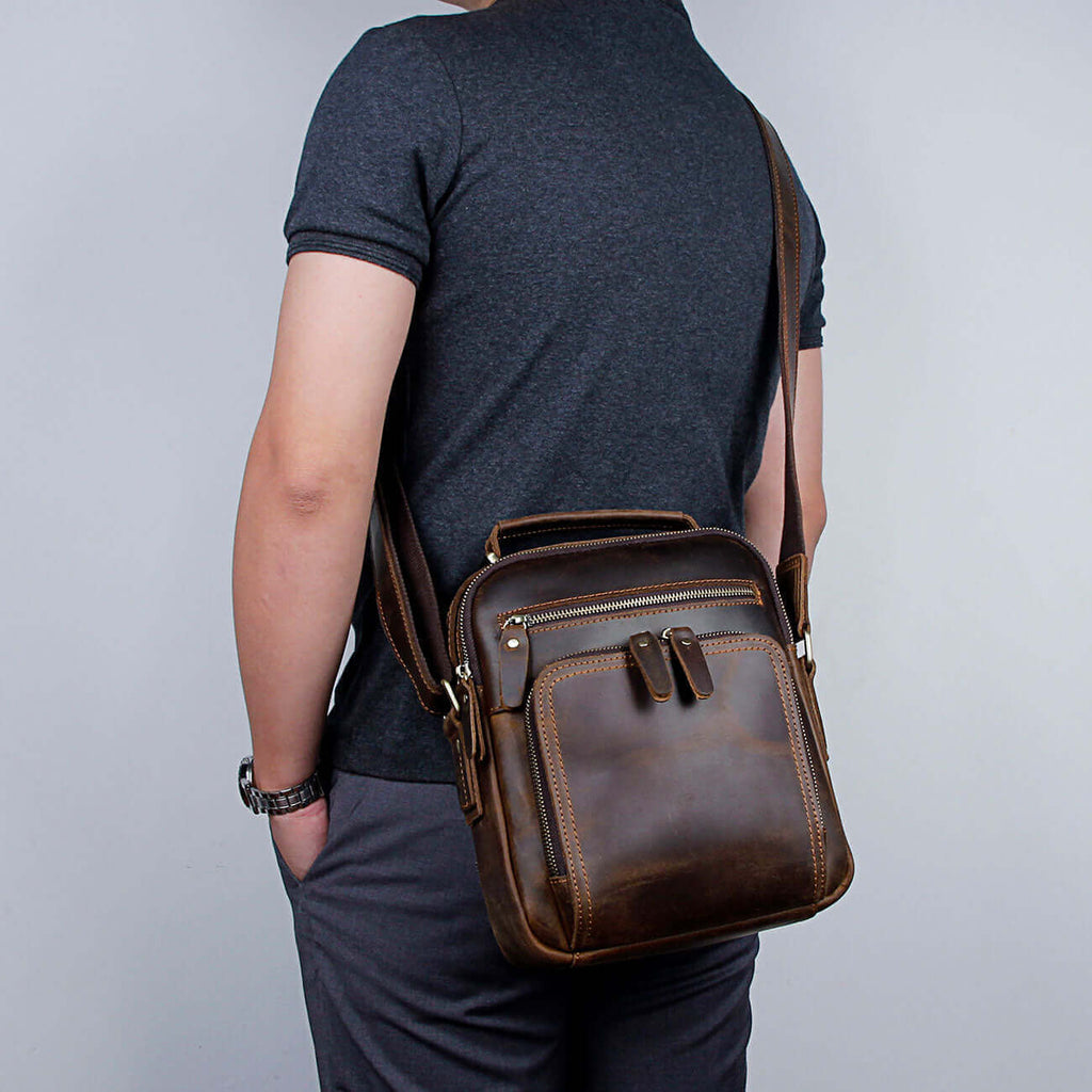 Brown leather crossbody bag for men with secure zippered closure.