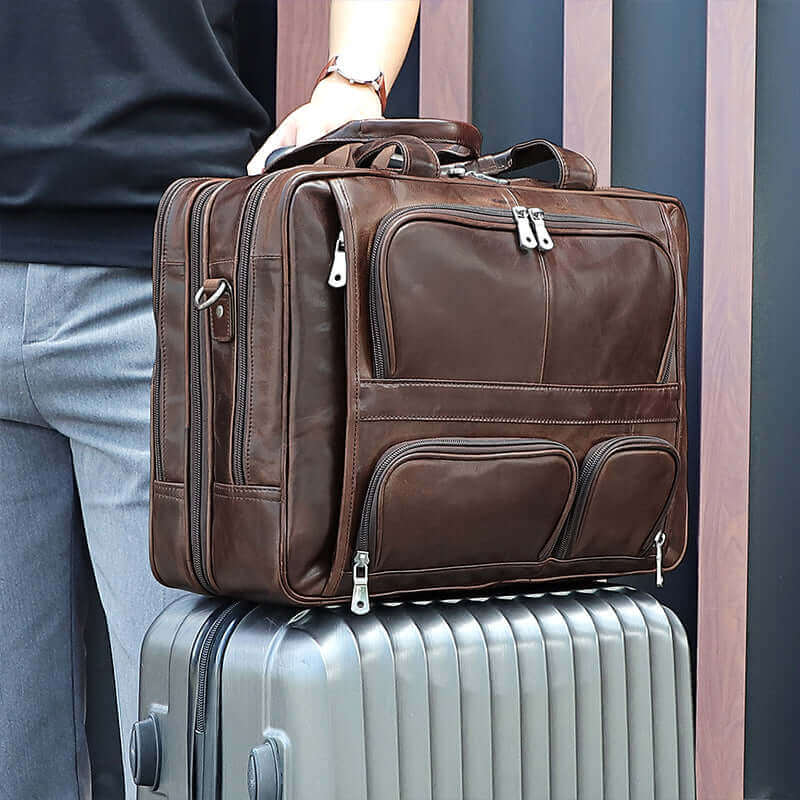 Leather bag attached to a suitcase with a strap.